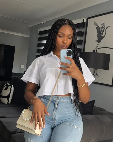 Nolu taking a mirror selfie in a white shirt and jeans